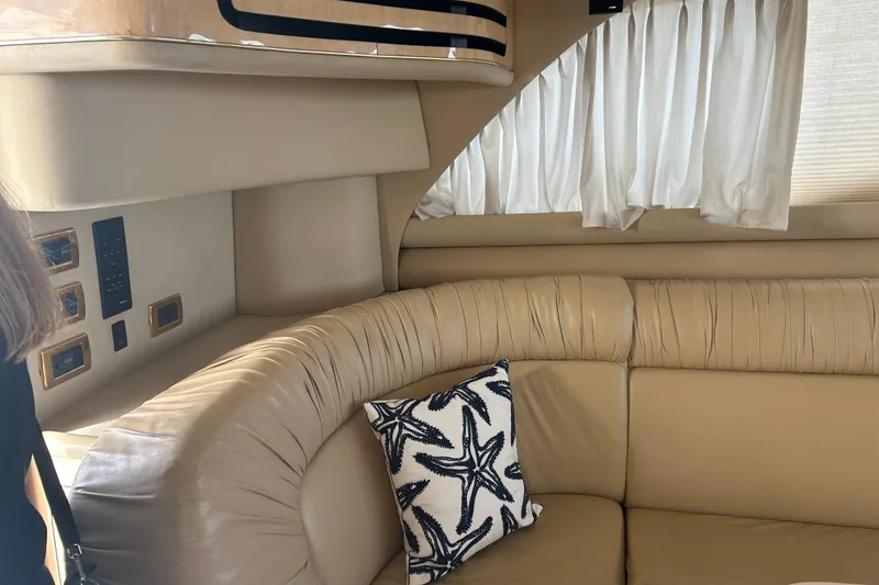 Slide: The Image of Interior of 2001 Sea Ray 480 Sedan Bridge with beige leather seating and starfish pillow. - 31