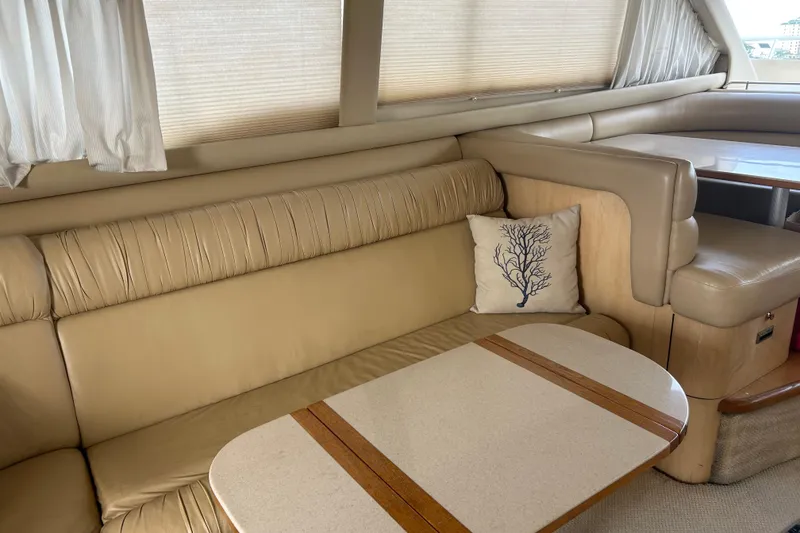 Slide: The Image of Interior of 2001 Sea Ray 480 Sedan Bridge with beige seating and decorative pillow. - 32
