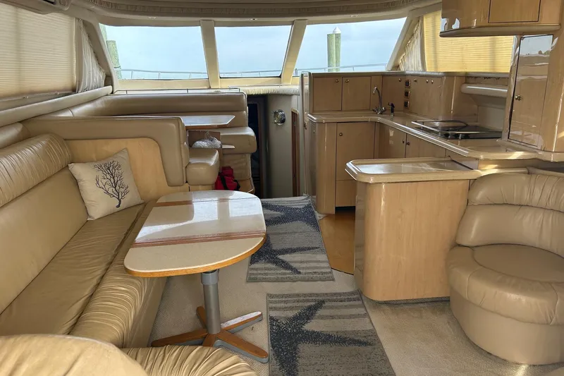 Slide: The Image of Luxurious interior of 2001 Sea Ray 480 Sedan Bridge yacht with beige leather seating. - 33