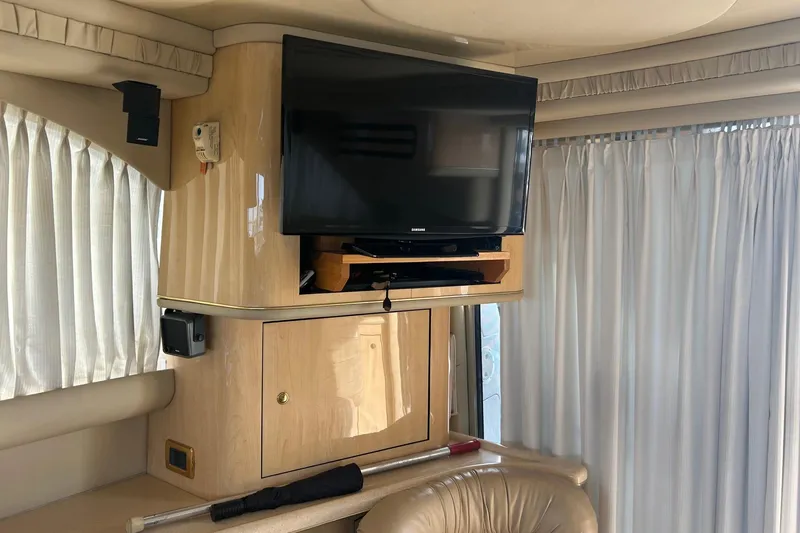Slide: The Image of Interior of 2001 Sea Ray 480 Sedan Bridge with TV and curtains. - 35
