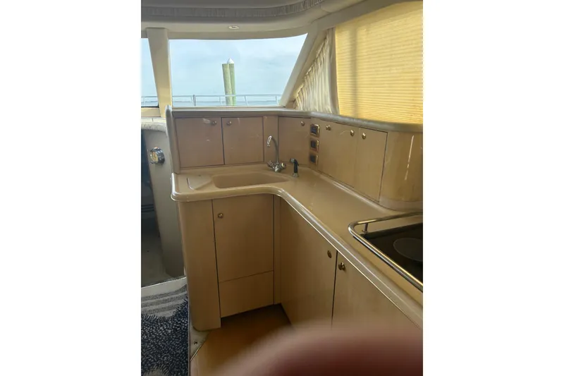 Slide: The Image of 2001 Sea Ray 480 Sedan Bridge yacht interior kitchen with cabinets and sink. - 36