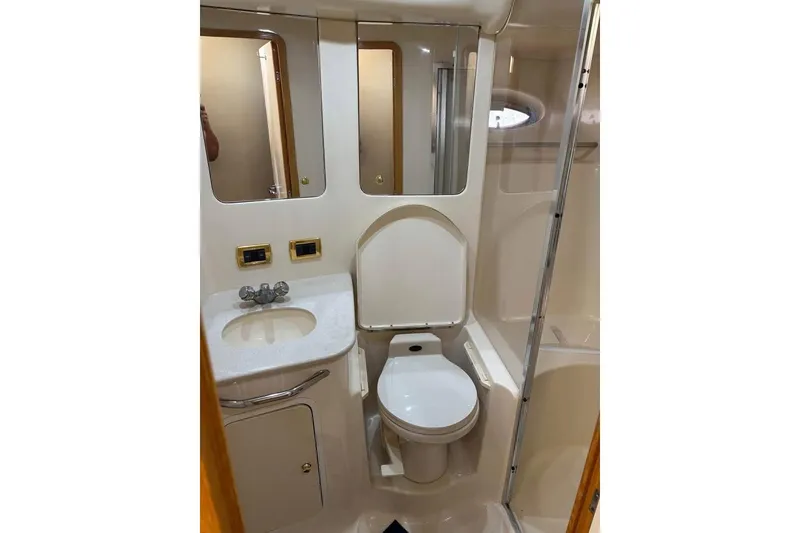 Slide: The Image of 2001 Sea Ray 480 Sedan Bridge bathroom with sink, toilet, and shower. - 39
