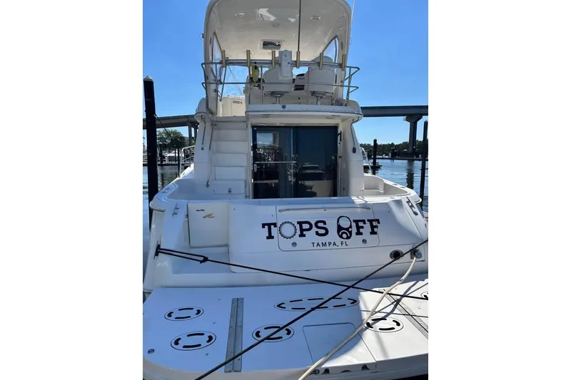 Slide: The Image of 2001 Sea Ray 480 Sedan Bridge yacht docked, rear view, named "Tops Off," Tampa, FL. - 4
