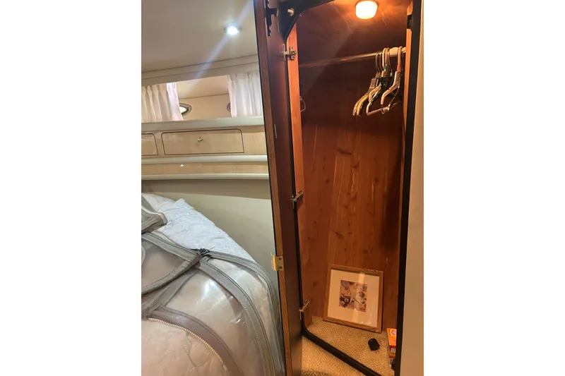 Slide: The Image of Interior of 2001 Sea Ray 480 Sedan Bridge showing a wooden closet with hangers. - 45