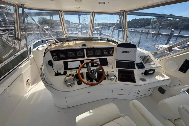 Slide: The Image of 2001 Sea Ray 480 Sedan Bridge helm with Simrad navigation, overlooking marina. - 7