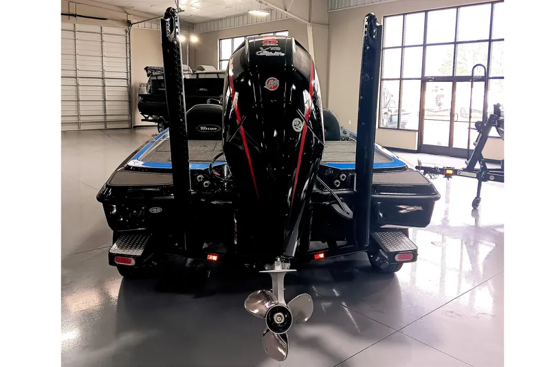 Slide: The Image of 2026 Triton 21XP Patriot boat in showroom, rear view with motor and propeller. - 6