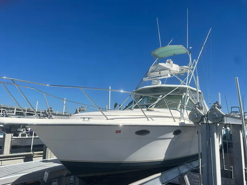 Slide: The Image of 1995 Tiara Sport 3100 boat docked under clear blue sky. - 3