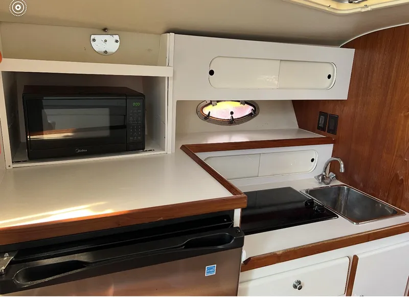 Slide: The Image of 1995 Tiara Sport 3100 yacht kitchen with microwave, sink, and stove. - 5