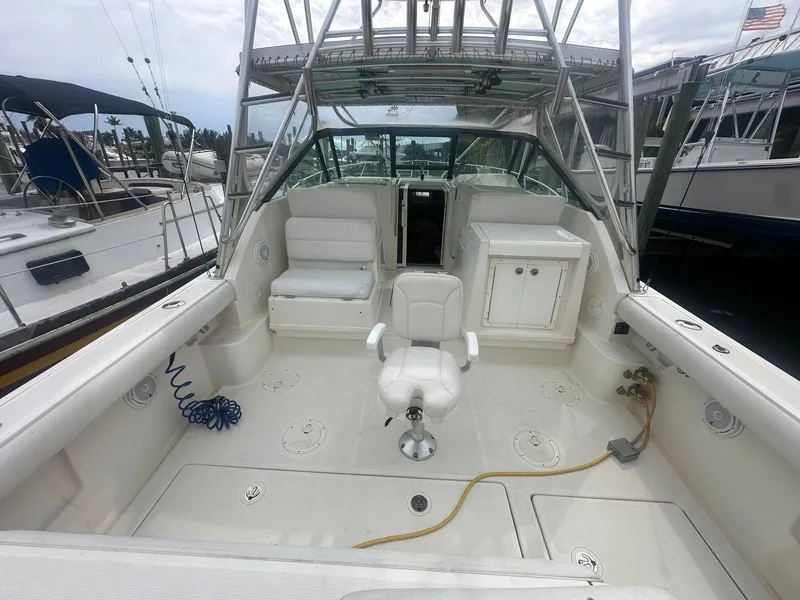Slide: The Image of 1995 Tiara Sport 3100 boat interior with seating and helm, docked at marina. - 9