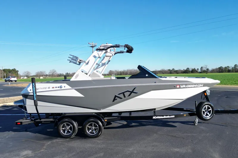 Slide: The Image of 2021 ATX Surf Boats 22 Type-S on trailer, sleek design, parked outdoors. - 4