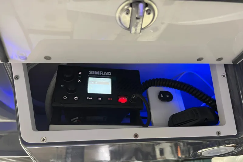 Slide: The Image of Simrad marine radio inside 2026 Robalo R257 Dual Console boat compartment. - 12
