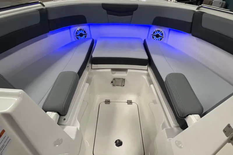 Slide: The Image of 2026 Robalo R257 Dual Console boat interior with blue LED lighting and cushioned seating. - 21