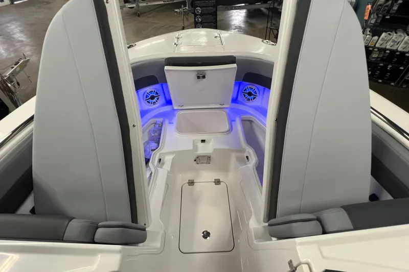Slide: The Image of 2026 Robalo R257 Dual Console boat interior with storage compartments and blue LED lighting. - 22