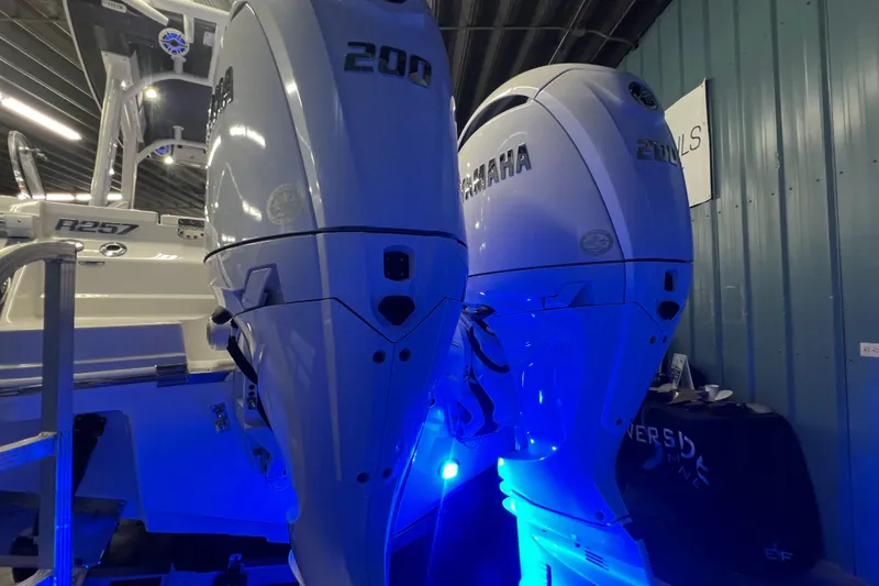 Slide: The Image of 2026 Robalo R257 Dual Console with Yamaha 200 engines, illuminated in blue light. - 26
