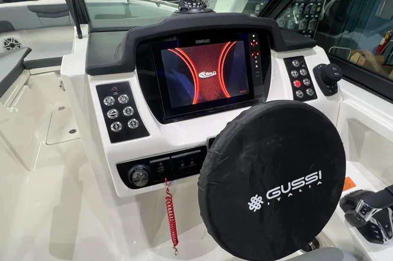 Slide: The Image of 2026 Robalo R257 Dual Console dashboard with Simrad display and Gussi Italia steering wheel. - 9