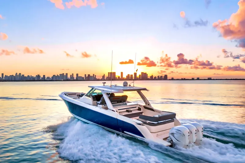 Slide: The Image of 2020 Tiara Yachts 43 LS cruising at sunset with city skyline backdrop. - 1