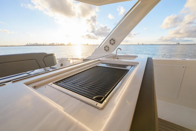 Slide: The Image of Luxury Tiara Yachts 43 LS 2020 with outdoor grill and ocean view at sunset. - 29