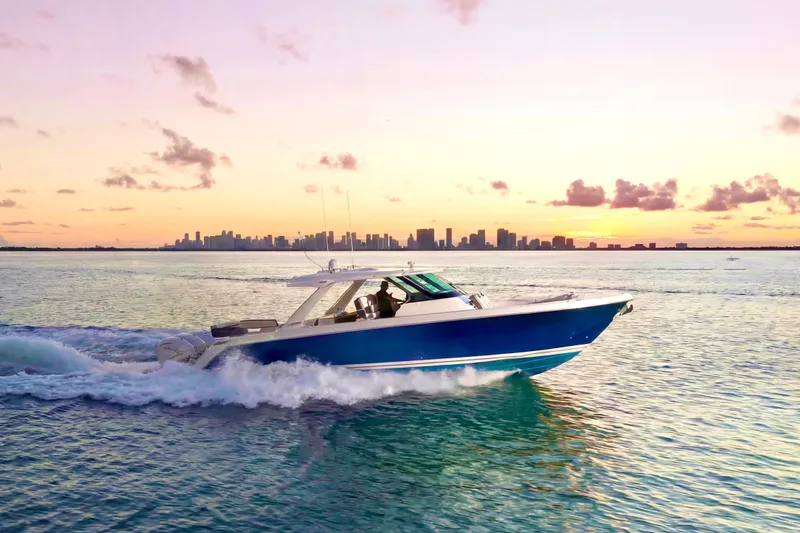 Slide: The Image of 2020 Tiara Yachts 43 LS cruising at sunset with city skyline in background. - 3