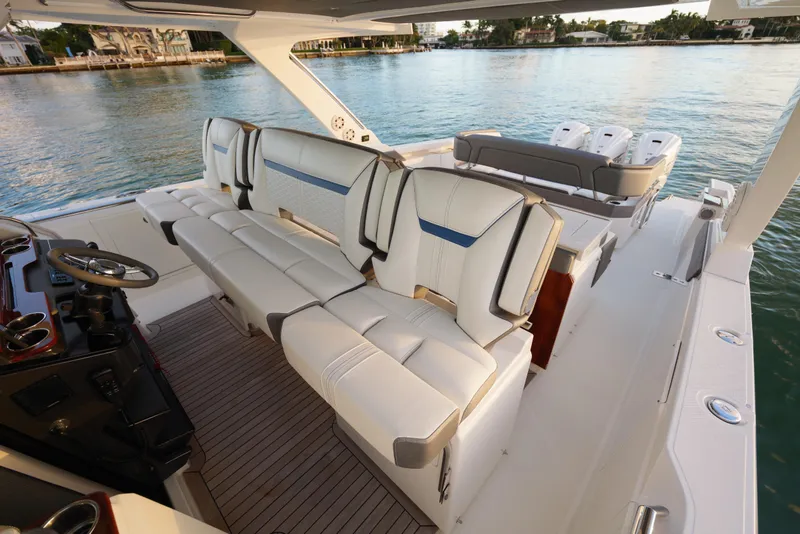 Slide: The Image of 2020 Tiara Yachts 43 LS interior with luxurious seating and helm, docked by serene waters. - 34