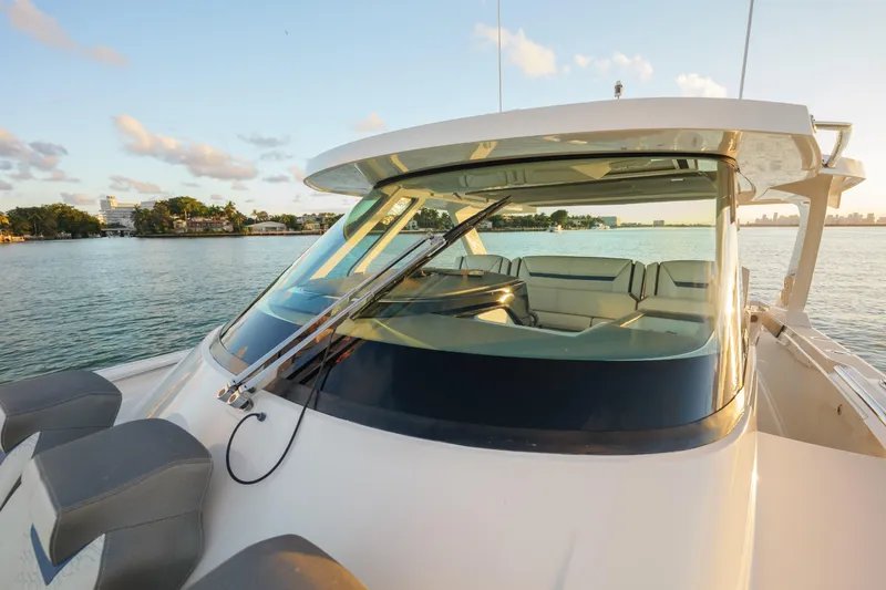 Slide: The Image of 2020 Tiara Yachts 43 LS on serene water at sunset, showcasing sleek design. - 42