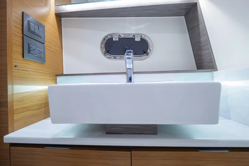 Slide: The Image of Modern bathroom sink on 2020 Tiara Yachts 43 LS, featuring sleek design and wood accents. - 62