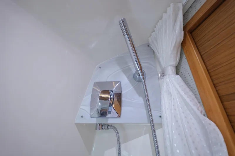 Slide: The Image of Shower area in 2020 Tiara Yachts 43 LS, featuring chrome fixtures and white curtain. - 63