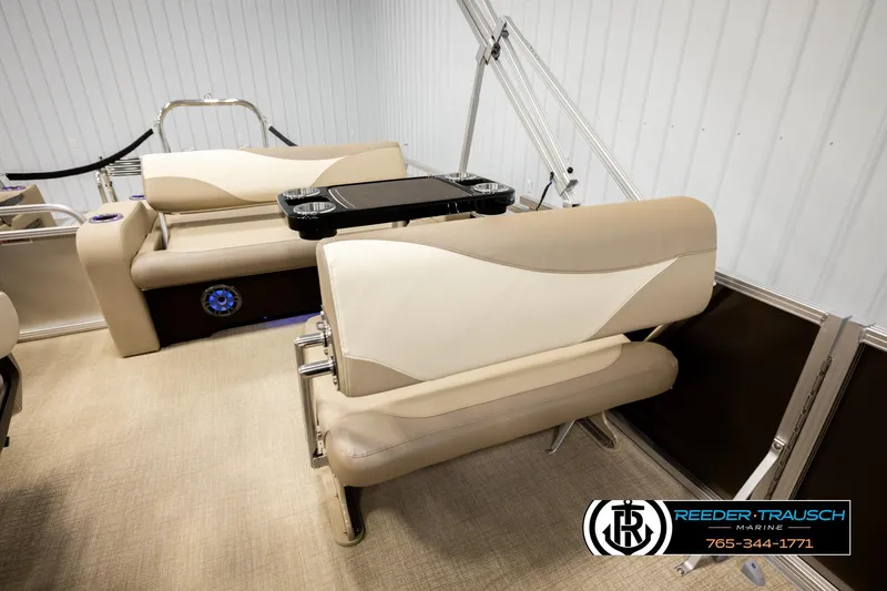 Slide: The Image of 2026 Avalon LSZ ENT boat interior with beige seating and cup holders, showcased by Reeder-Trausch Marine. - 24