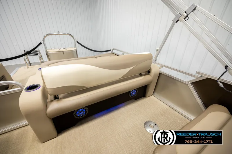 Slide: The Image of 2026 Avalon LSZ ENT pontoon boat interior with beige seating and blue LED lighting. - 26