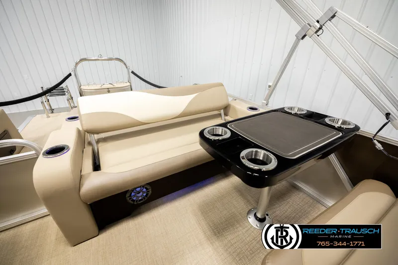 Slide: The Image of 2026 Avalon LSZ ENT boat interior with beige seating and black table featuring cup holders. - 28