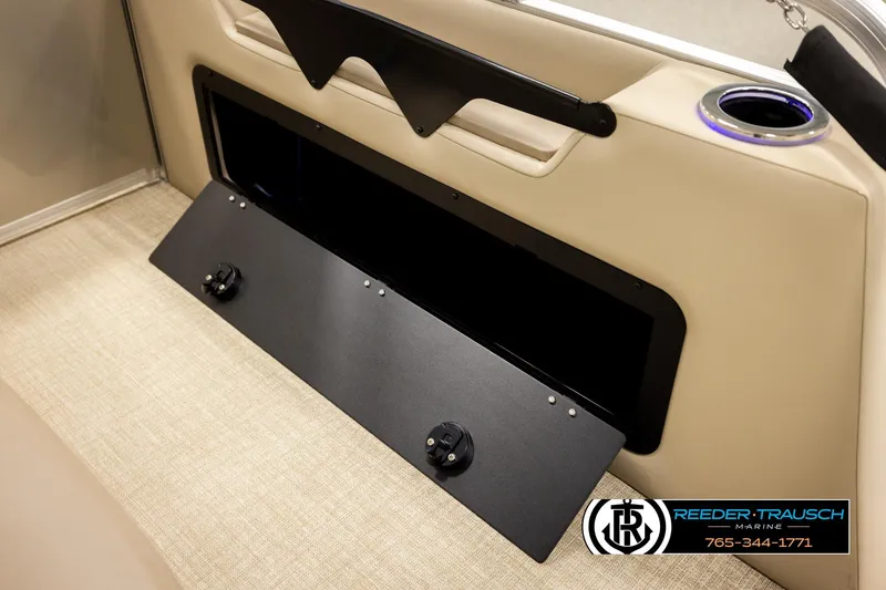 Slide: The Image of 2026 Avalon LSZ ENT boat interior storage compartment with cup holder and beige seating. - 33