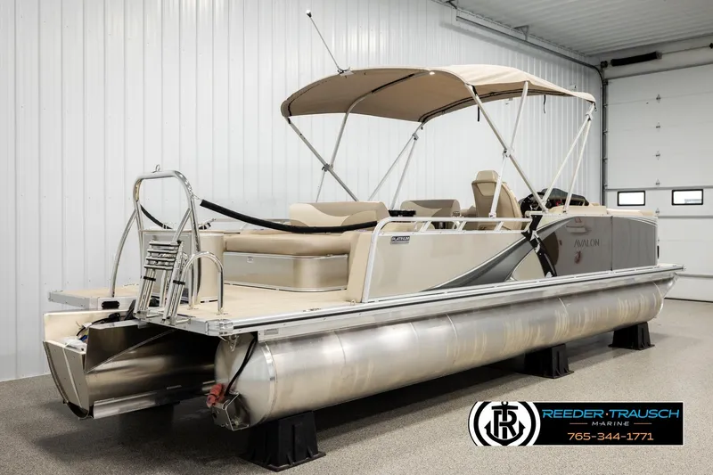 Slide: The Image of 2026 Avalon LSZ ENT pontoon boat in indoor showroom with canopy and seating. - 6