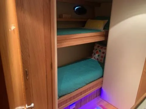 Slide: The Image of Bunk beds in 1988 Viking Motor Yacht cabin with teal bedding and ambient lighting. - 20