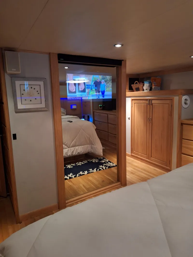Slide: The Image of Interior of 1988 Viking Motor Yacht bedroom with wooden cabinets and cozy bedding. - 23