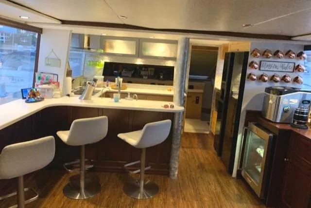 Slide: The Image of Luxurious interior of a 1988 Viking Motor Yacht with modern kitchen and bar stools. - 28