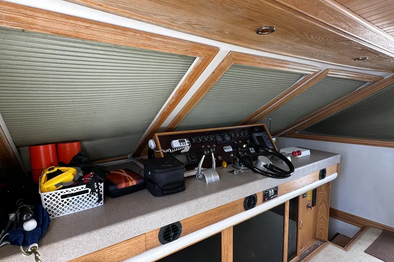 Slide: The Image of 1988 Viking Motor Yacht helm station with control panel and storage compartments. - 30