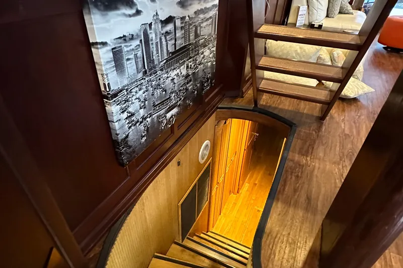 Slide: The Image of Interior of 1988 Viking Motor Yacht with wooden stairs and cityscape artwork. - 38