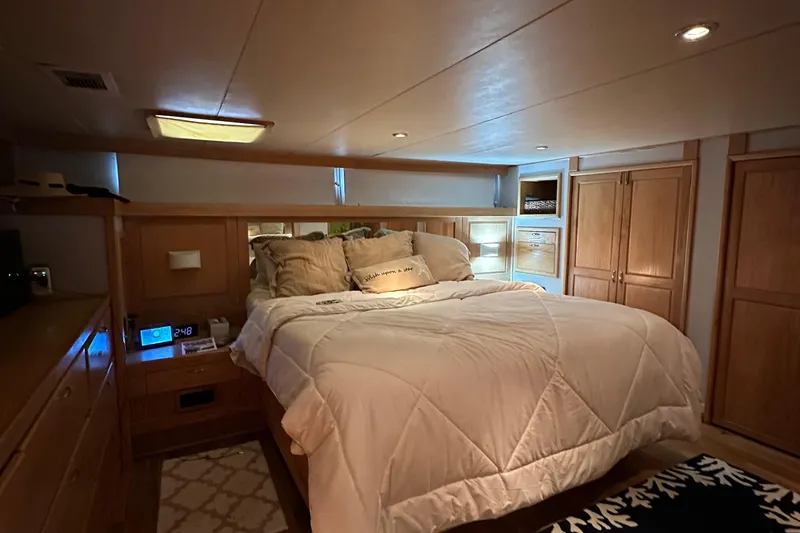 Slide: The Image of Luxurious bedroom in a 1988 Viking Motor Yacht with cozy bedding and wooden cabinetry. - 44
