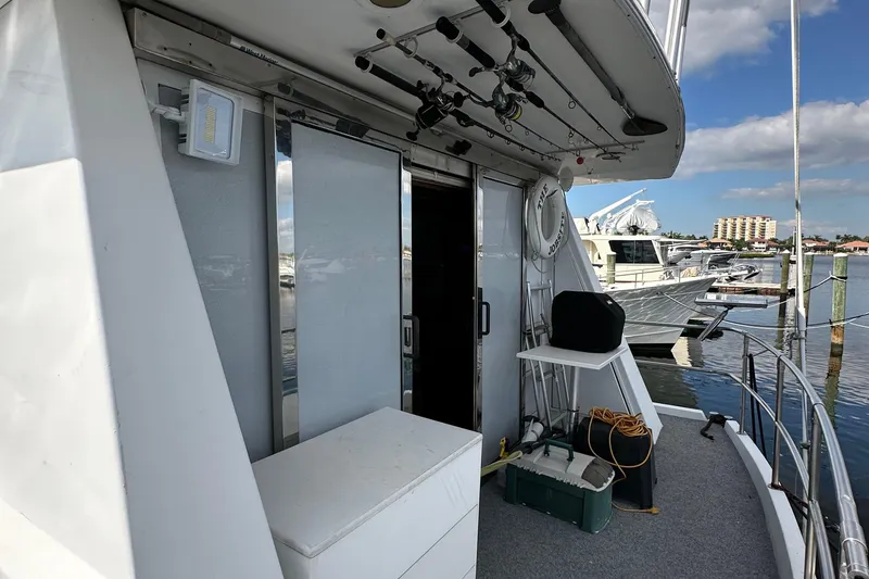 Slide: The Image of 1988 Viking Motor Yacht deck with fishing rods, storage, and marina view. - 47
