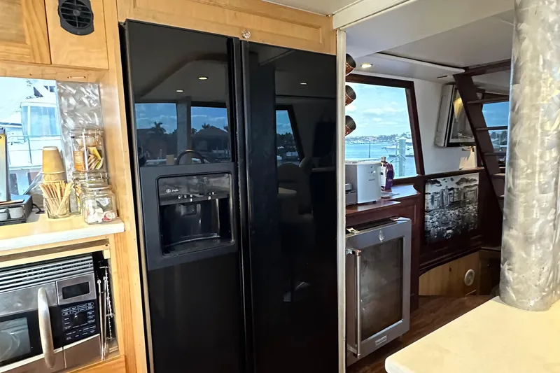 Slide: The Image of Interior of 1988 Viking Motor Yacht kitchen with black refrigerator and microwave. - 48