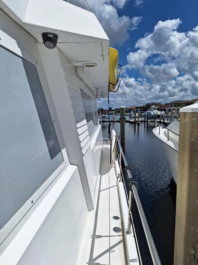 Slide: The Image of 1988 Viking Motor Yacht docked at a marina under a partly cloudy sky. - 5
