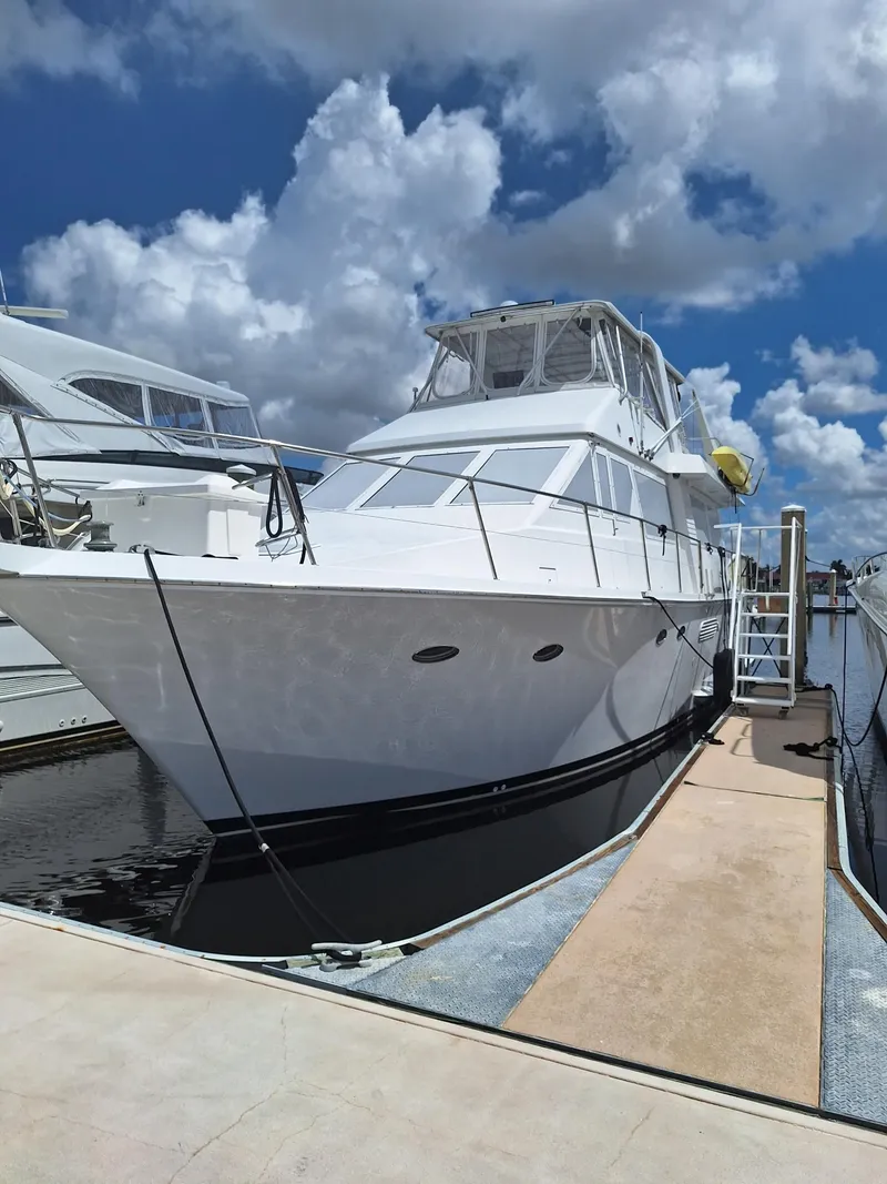 Slide: The Image of 1988 Viking Motor Yacht docked under a partly cloudy sky. - 9