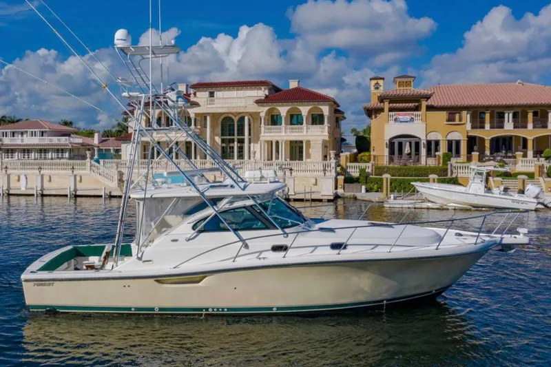 The Image of 2004 Pursuit 3800 Express yacht docked near luxury waterfront homes. - 0