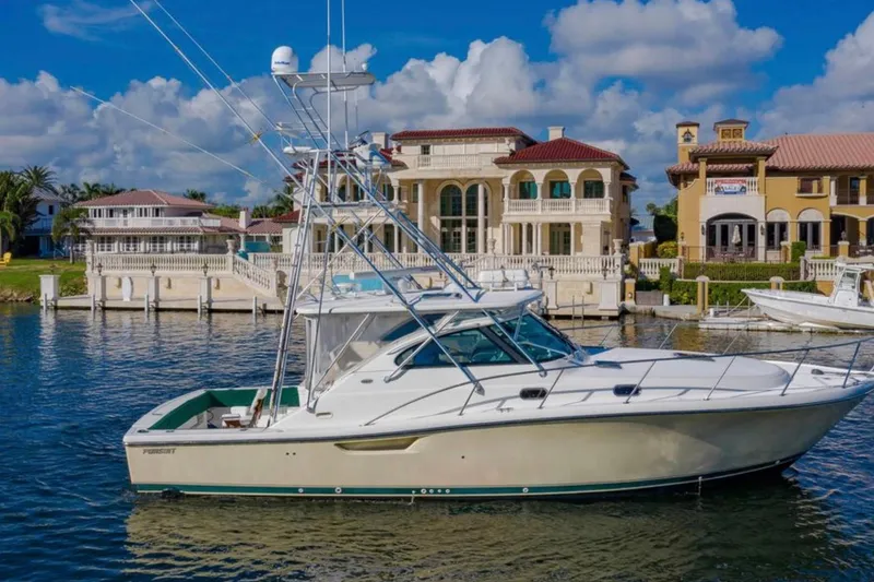 Slide: The Image of 2004 Pursuit 3800 Express yacht docked near luxury waterfront homes. - 1