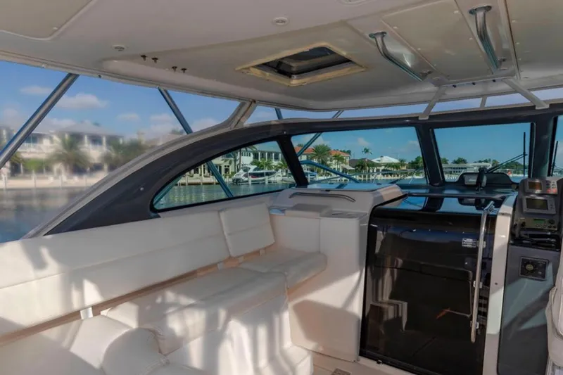 Slide: The Image of Interior of a 2004 Pursuit 3800 Express yacht with white seating and navigation equipment. - 10