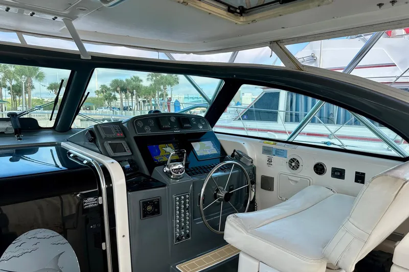 Slide: The Image of 2004 Pursuit 3800 Express boat cockpit with steering wheel and navigation screens. - 13