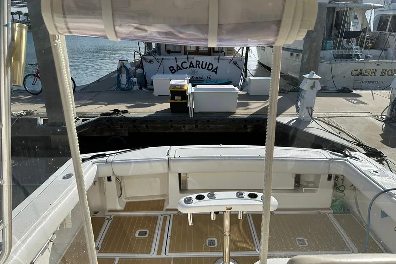 Slide: The Image of 2004 Pursuit 3800 Express boat docked at marina with fishing equipment. - 16