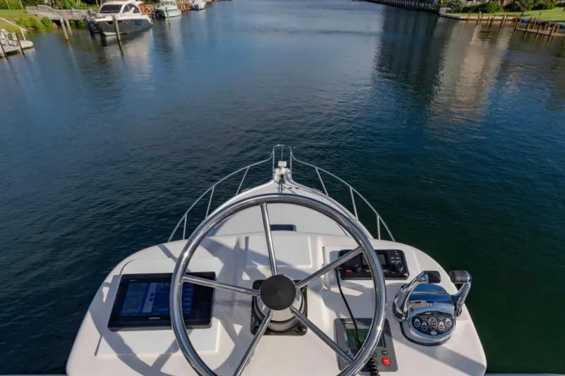 Slide: The Image of Helm view of 2004 Pursuit 3800 Express boat on a calm waterway. - 20