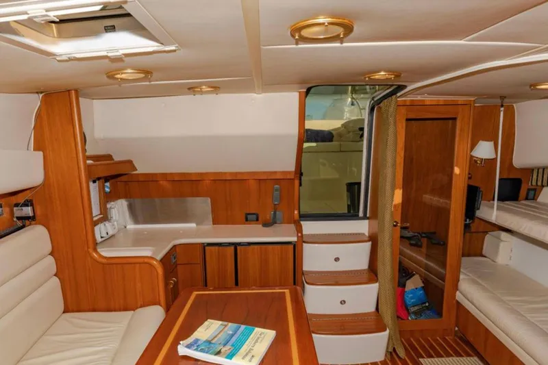 Slide: The Image of Interior of 2004 Pursuit 3800 Express yacht with wood finishes and cozy seating area. - 4