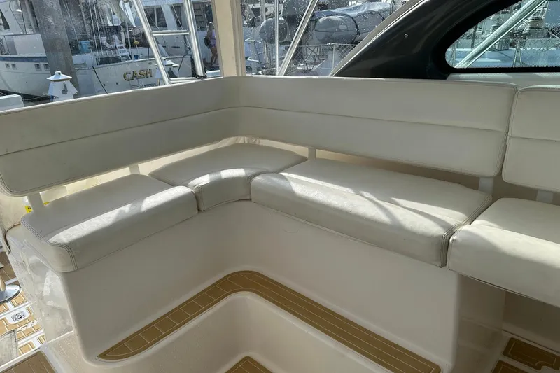 Slide: The Image of 2004 Pursuit 3800 Express boat interior with white cushioned seating. - 8