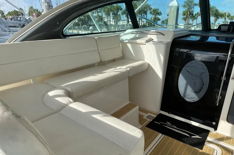 Slide: The Image of 2004 Pursuit 3800 Express boat interior with white seating and nautical decor. - 9